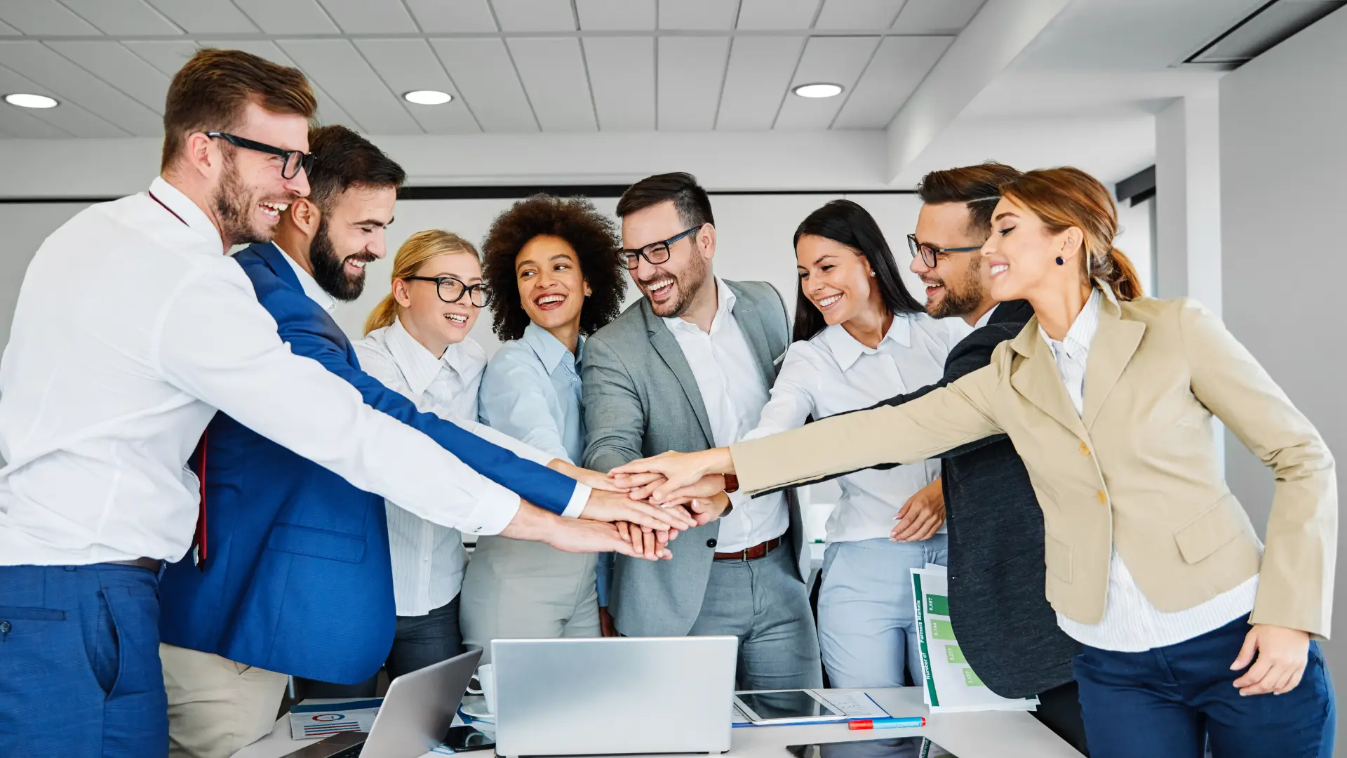 A united team placing hands together at work